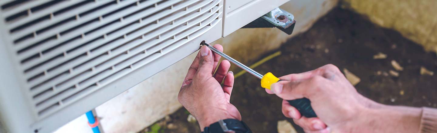 Technician servicing an outdoor HVAC unit