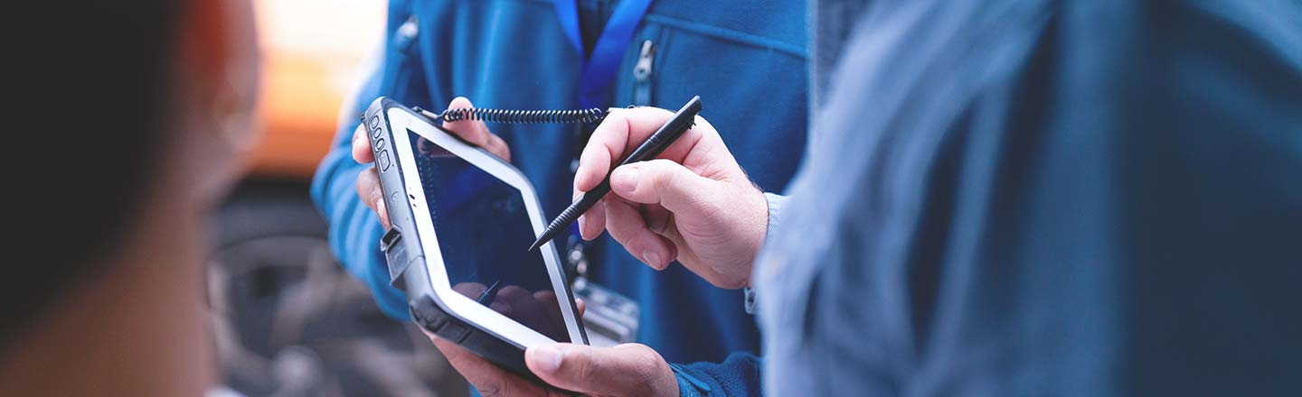Technicians reviewing data on a rugged tablet in the field
